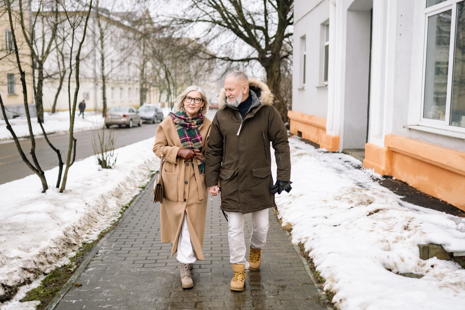Older couple walking together holding hands
